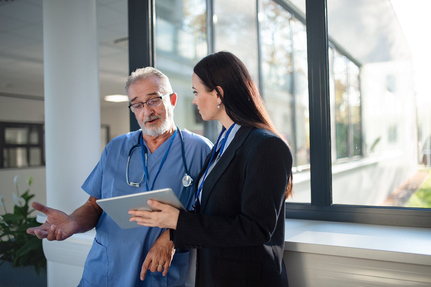 Seller-holding-tablet-explaning-to-doctor-in-hospital-1464782725